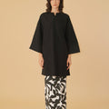 standing pose of woman donning black long kurung blouse