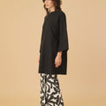 woman posing sideways wearing long kurung blouse black