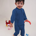 happy baby boy wearing steel blue baby baju melayu set, playing toys