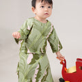 baby girl wearing estate print baby kurung dress and playing toys