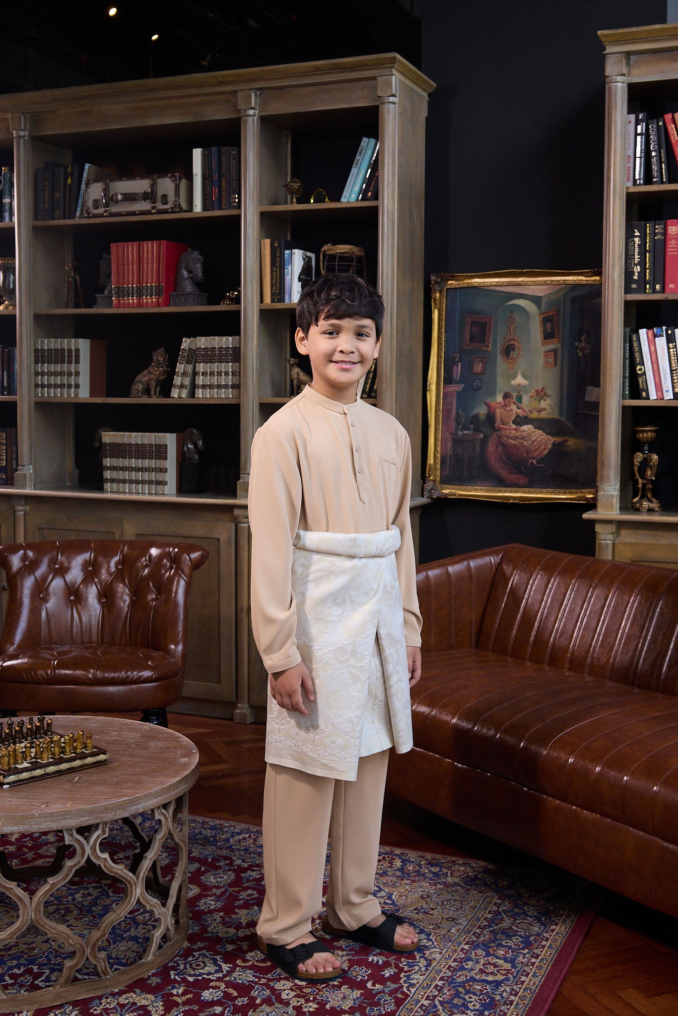 boy posing standing sideways in boy baju melayu set caramel