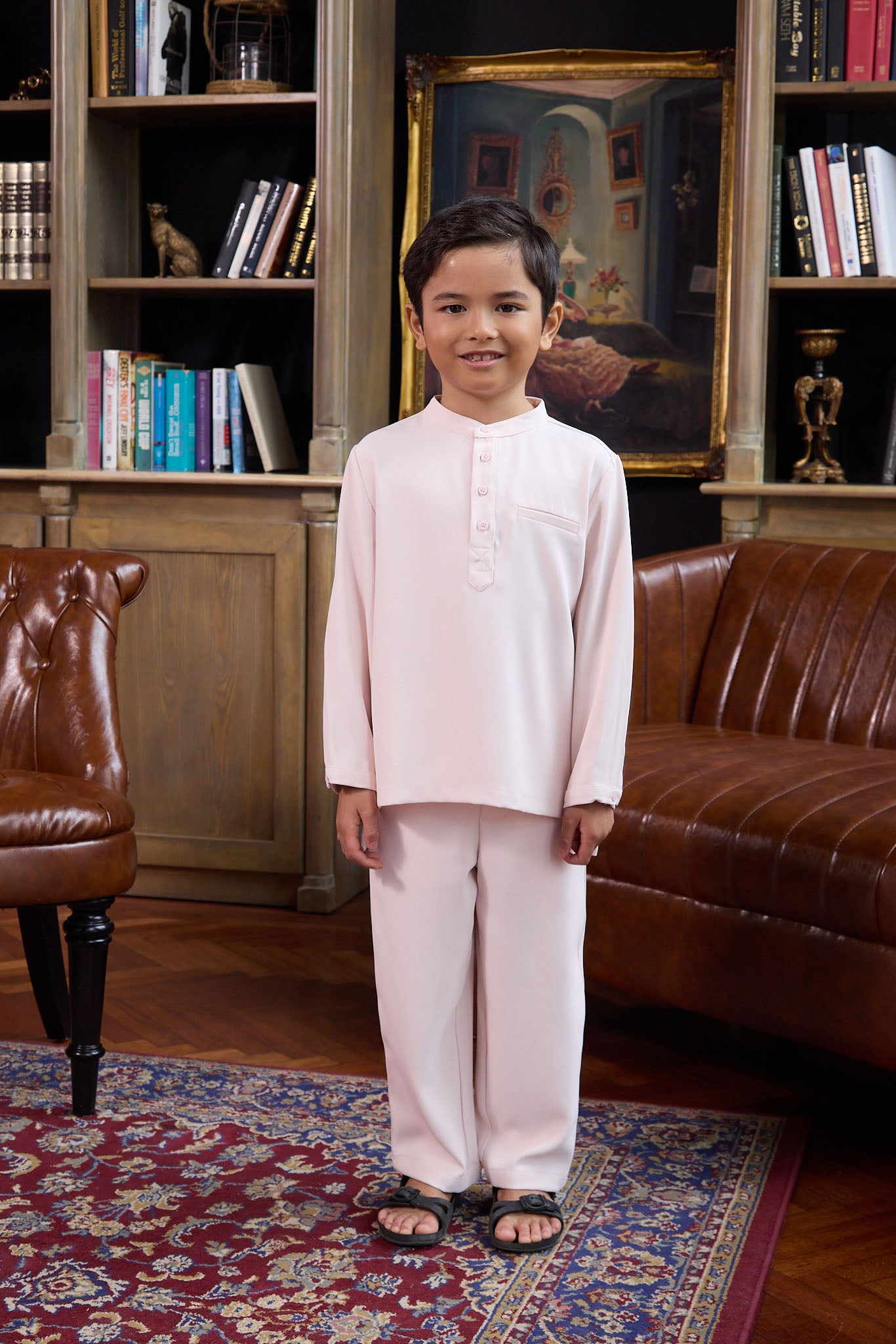 young boy posing in pink boy baju melayu set