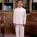 young boy posing in pink boy baju melayu set