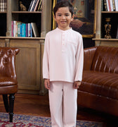 young boy posing in pink boy baju melayu set