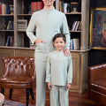 father and son smiling, standing pose together in sage green baju melayu set