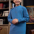 smiling boy with clasped hand posing, wearing steel blue boy baju melayu set