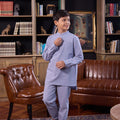 young boy holding placket, wearing stone blue boy baju melayu set