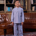 little boy smiling and posing in stone blue boy baju melayu set