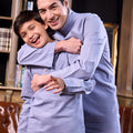 father and son happily posing wearing baju melayu set stone blue