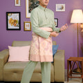 men wearing traditional baju melayu set sage green poses in living room 