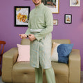smiling man in baju melayu set sage green traditional outfit standing pose