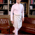 man in baju melayu set soft pink poses for the camera