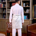 man donning soft pink baju melayu set and posing backwards