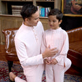 man and young boy in baju melayu set soft pink, posing happily together 