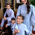 A family poses joyfully donning the warisan raya stone blue colour attire