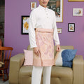 man donning white baju melayu set stands posing sideway 