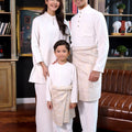 happy family dressed in white attire from warisan raya collection, standing pose for the camera