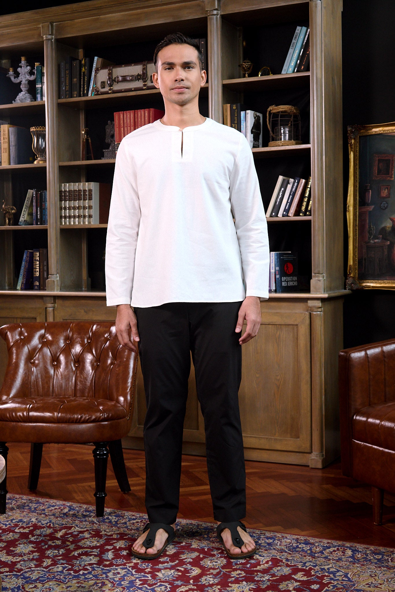 man stands confidently wearing white men teluk belanga top