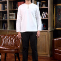 man stands confidently wearing white men teluk belanga top