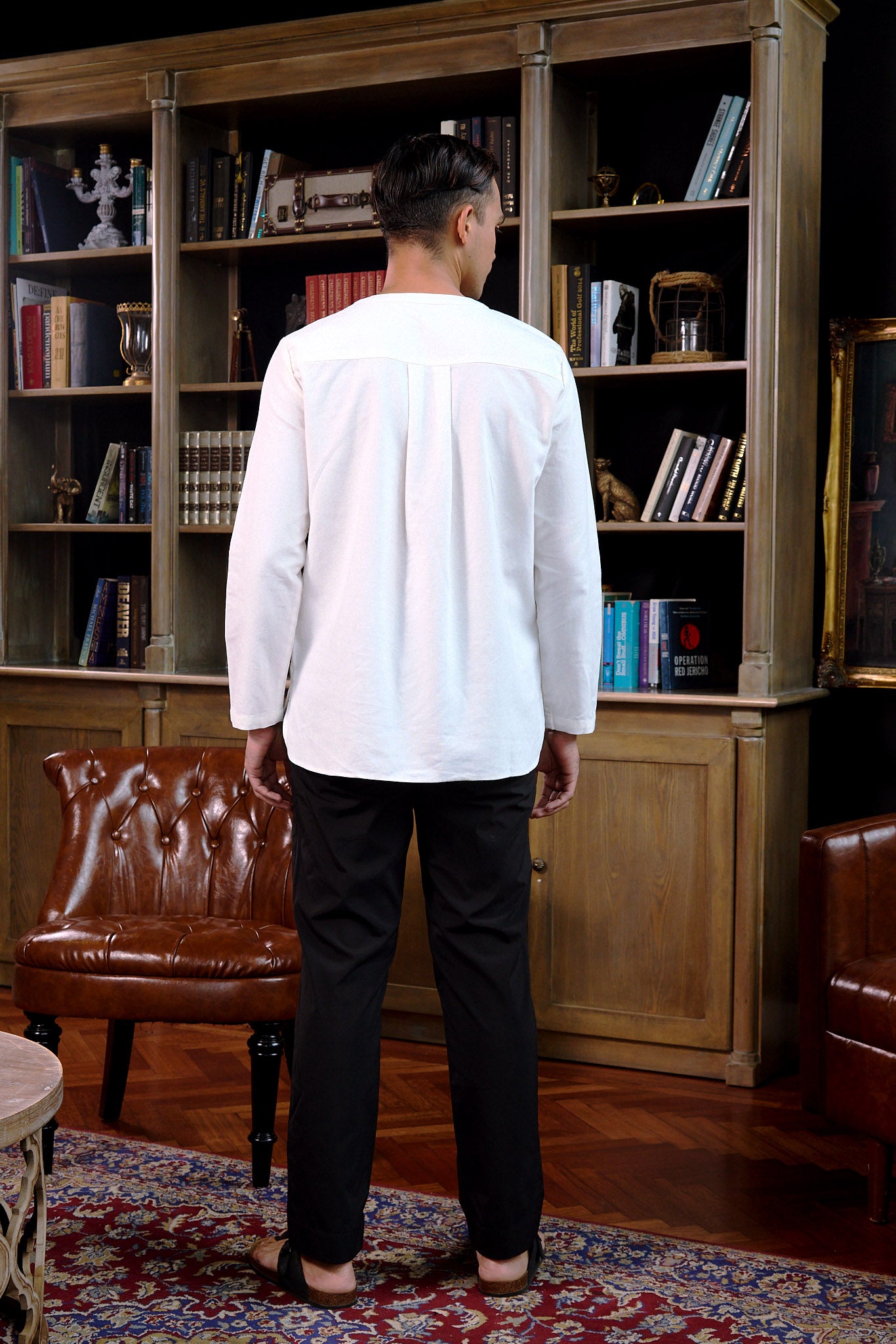 man standing in back view dressed teluk belanga white top