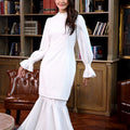 woman dressed in white polka dot jasmine kurung set and posing