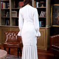 woman posing backwards in white polka dot jasmine kurung set