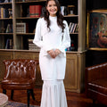 smiling woman with clasping hands dressed in jasmine kurung set white polka dot 