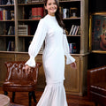 cheerful woman posing for the camera, dressed in white polka dot jasmine kurung set