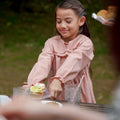 girl in checked red dress serving cupcake